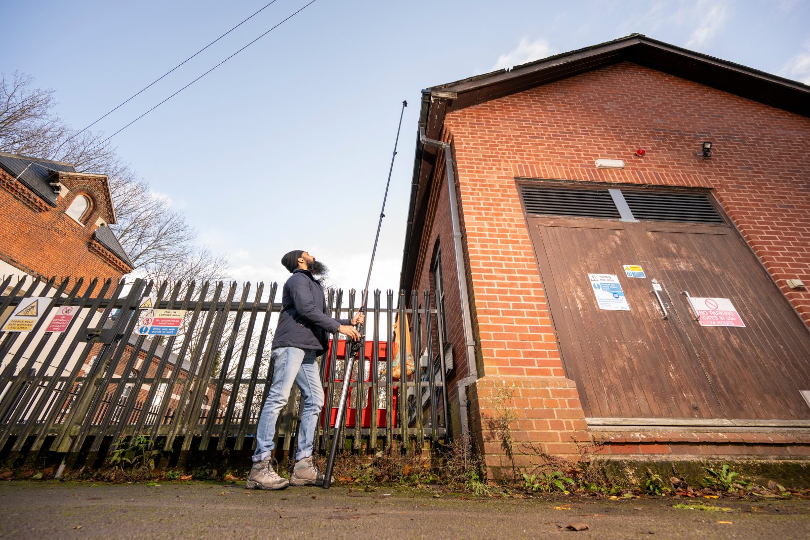 Chartered building surveyor inspecting the roof using a telescopic camera.