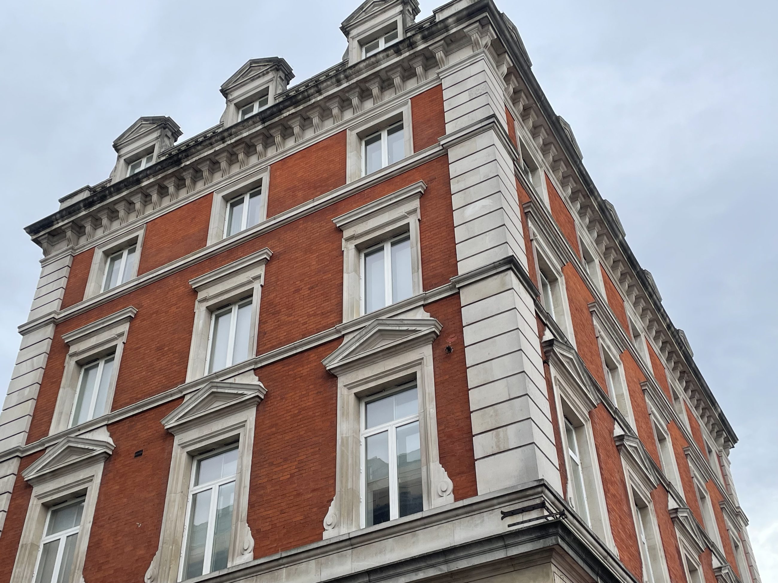 Georgian building used for commercial purposes, spread over multiple floors on a cloudy blue sky back-drop