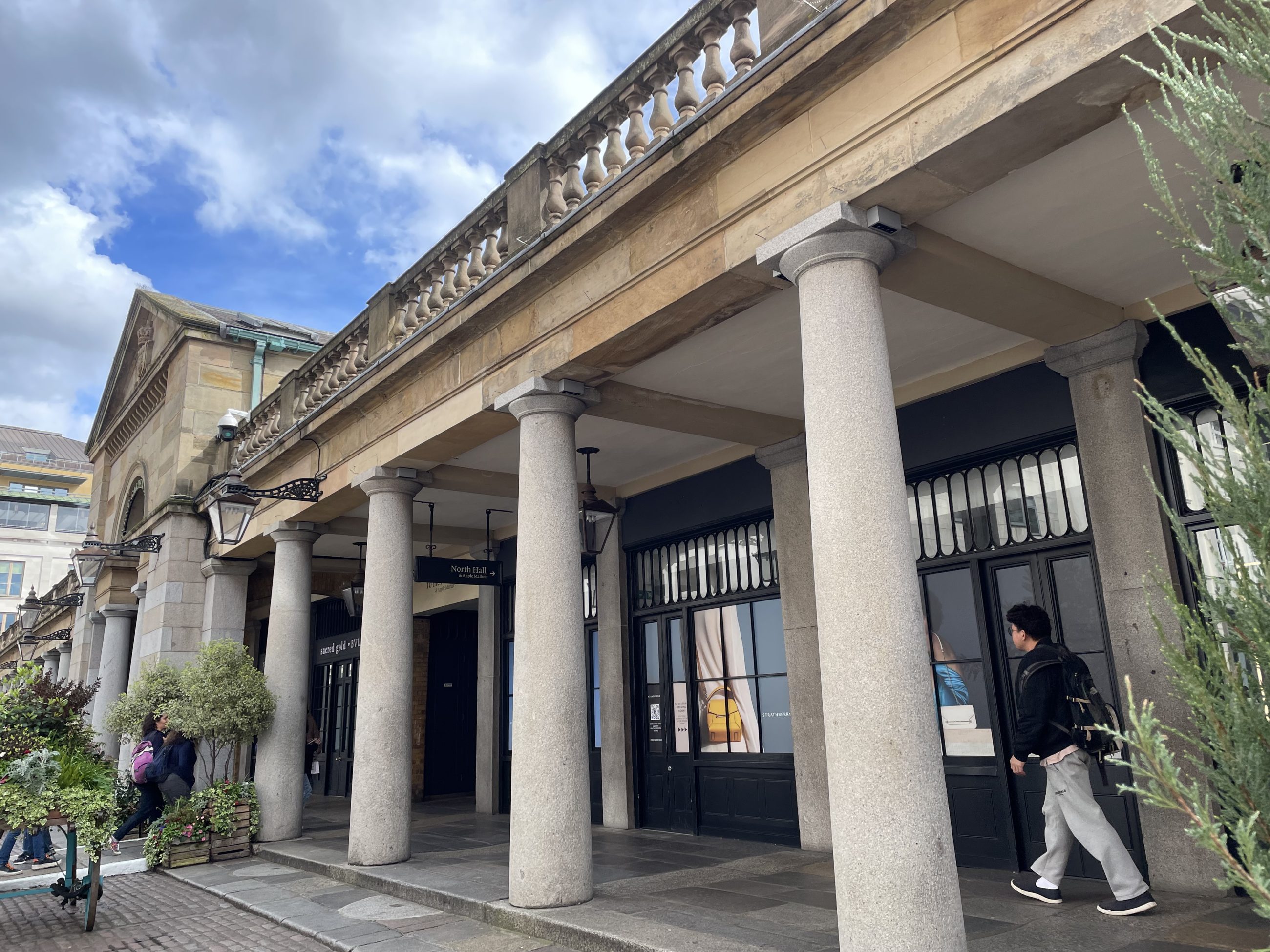 Entrance of old building now used for commercial purposes, with stone walls, pillars and decorative features