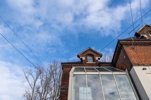 Abstract shot of traditional commercial building with brick and glass, blue sky and tree back-drop