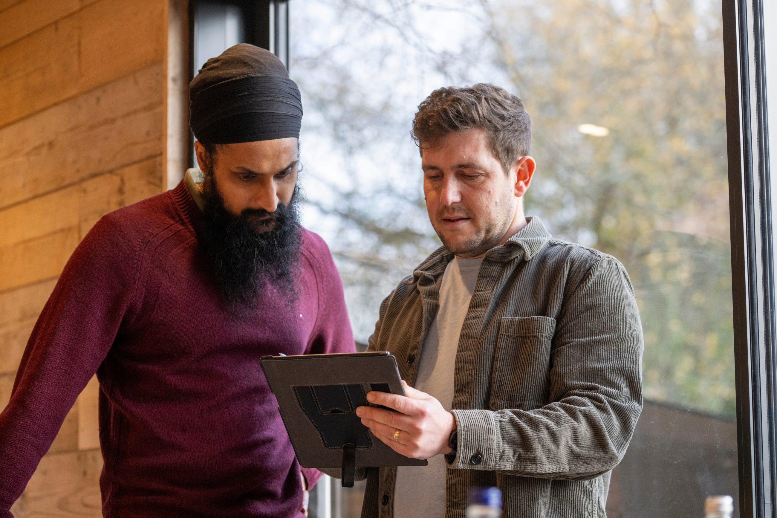 Harjit and Derek of Bressummer A.R.K discuss an expert witness report together within a contemporary office setting